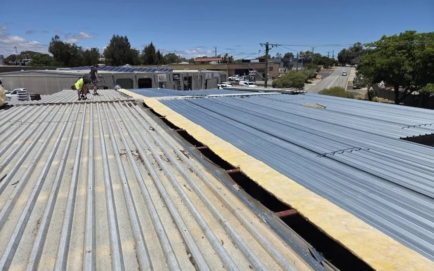 Commercial roof part way through re-sheeting with new insulation visible