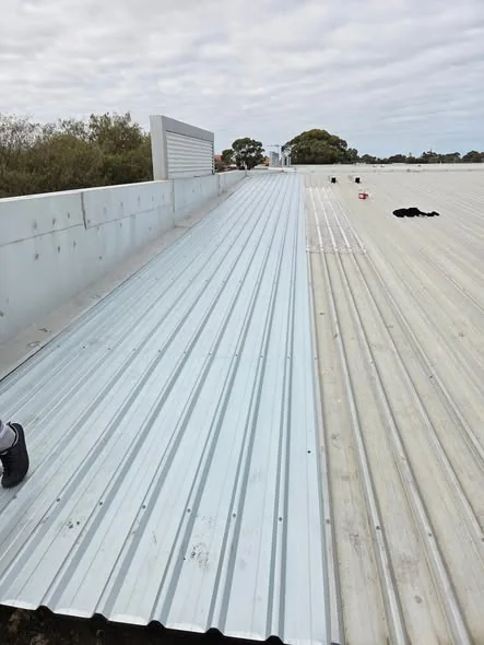Long run of new metal roof sheeting installed across a large roof